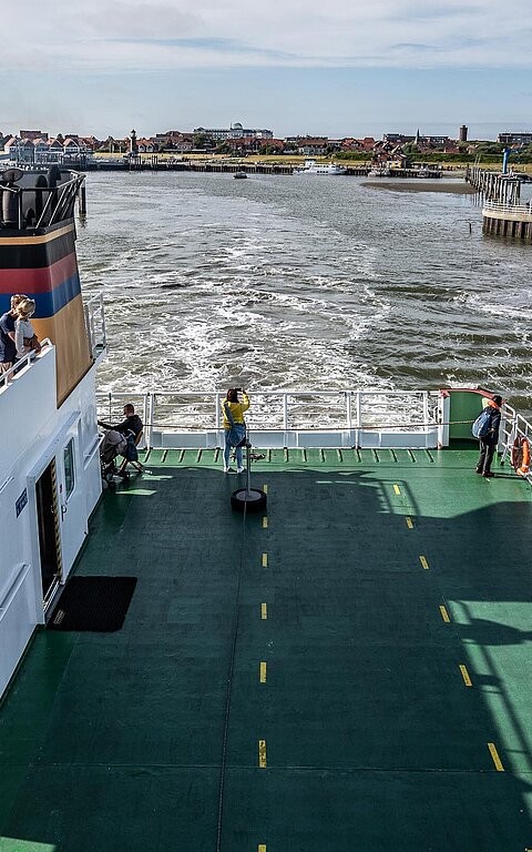 Anreise mit der großen Inselfähre nach Juist, Foto vom Oberdeck auf übers Freideck mit Wattenmeer und Juister Hafen
