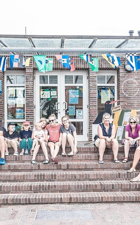 Eingang des Nationalpark-Haus auf Juist mit Menschen auf der Treppe