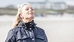 Frau am Strand auf Juist atmet tief ein