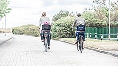 Paar fährt auf Juist Fahrrad, Blick von hinten auf ihre Rücken