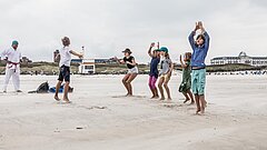 Gruppe an Kindern am Juister Strand bei einem Sportangebot