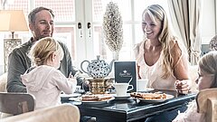 Familie mit Kindern beim Familienurlaub auf Juist im Restaurant mit Tee und Waffeln