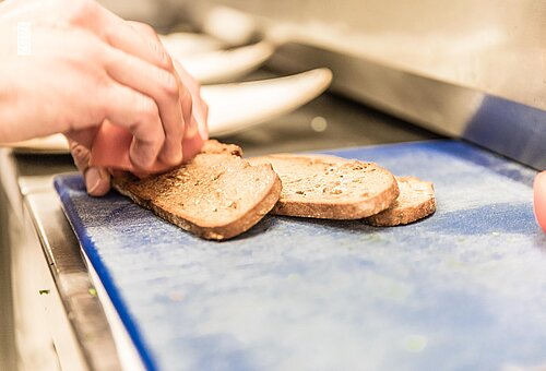 Person schneidet Brot in einer Küche auf Juist