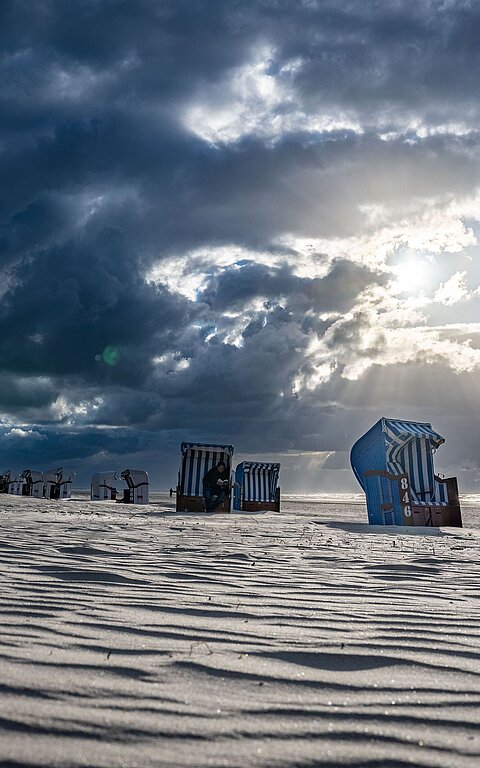 Strandkorb im Juister Strand mit Sonne und Wolken