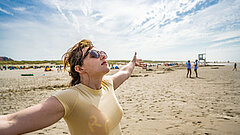 Frau am Strand auf Juist atmet tief ein