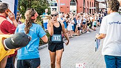 Läuferin beim Insellauf einem Wettkampf auf Juist, die eine Frage stellt und eine Geste mit der Hand macht