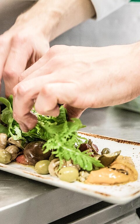 Koch bereitet Tapas vor in einer Küche eines Restaurants auf Juist