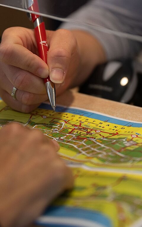 Beratung in den Tourist-Informationen auf Juist auf einer Landkarte